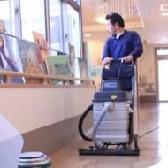 床を業務用掃除機で清掃する北進のスタッフ